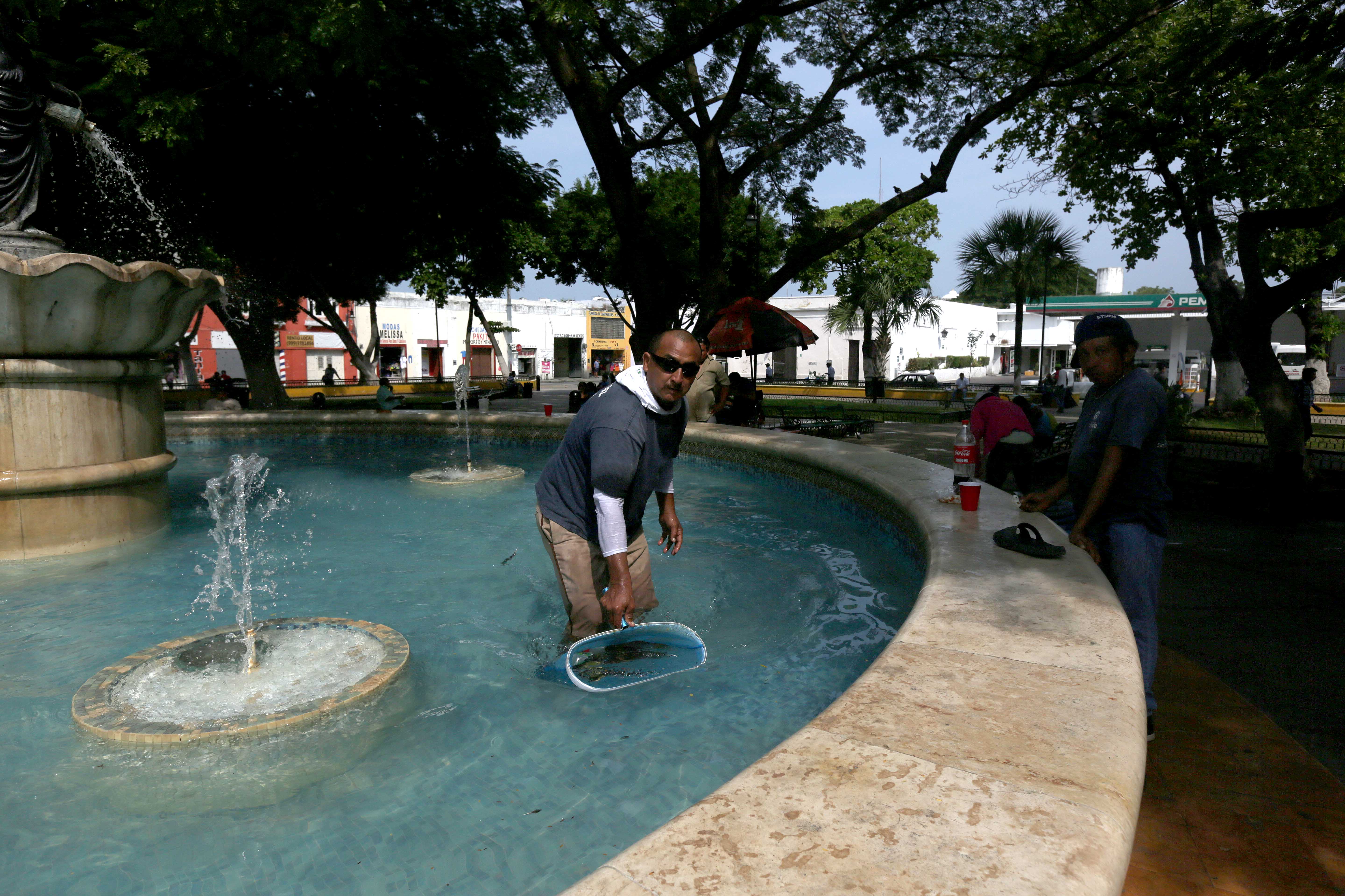 Trabajadores limpian fuente