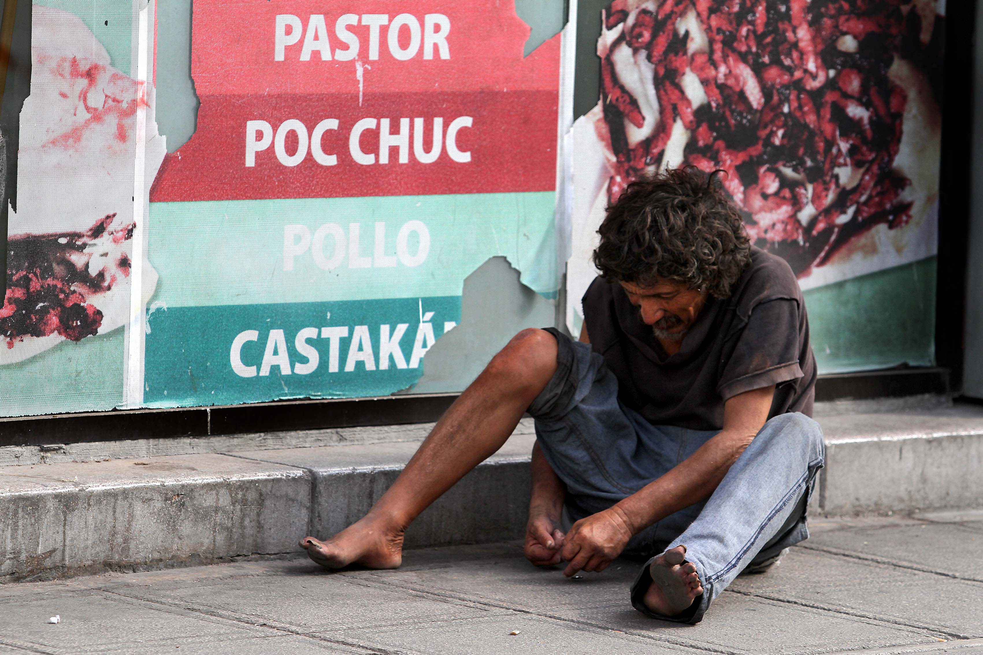 Indigente busca refugio con imagenes de alimento atrás